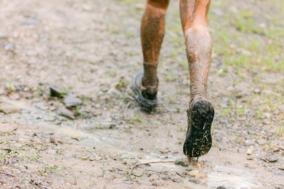 Close-up of muddy legs running on a wet trail, capturing the thrill of outdoor adventure.