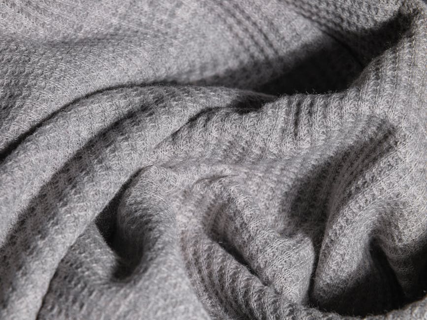 Close-up image of soft gray knitted fabric with intricate texture.