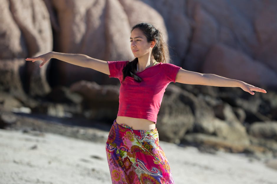A young woman performs yoga poses on a sunny beach in Mexico, embracing nature and mindfulness.