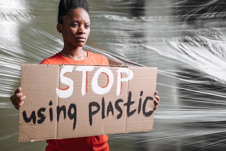 An activist holds a sign reading 'Stop using plastic' during a protest indoors.
