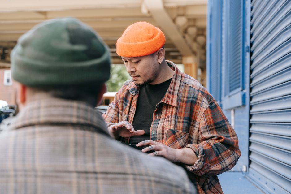 Urban scene featuring a man in orange beanie with plaid shirt, captured outdoors.